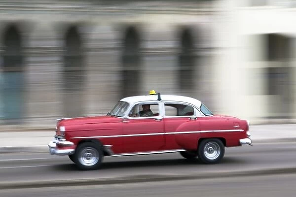 Panned shot of vintage American car on The Malecon, Havana, Cuba, West Indies, Caribbean, Central America