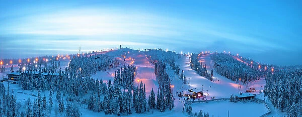 Winter dusk over the snowy ski slopes of Ruka tourist resort, aerial view, Kuusamo, Northern Ostrobothnia, Lapland, Finland, Europe