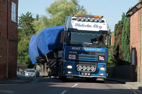 DAF 95 XF wide load truck carrying a life boat through a small village