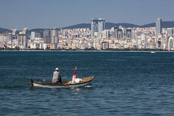 A man in a small boat off the island of Büyükada, one of the Princes` Islands near Istanbul, Turkey