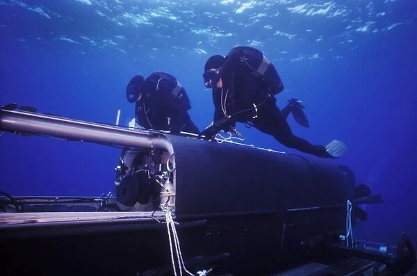 Combat swimmers swim above a Seal Delivery Vehicle