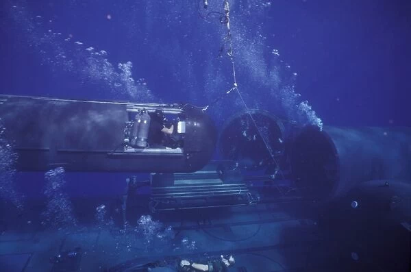 A SEAL Delivery Vehicle on tether connected to the dry deck shelter on USS Kamehameha