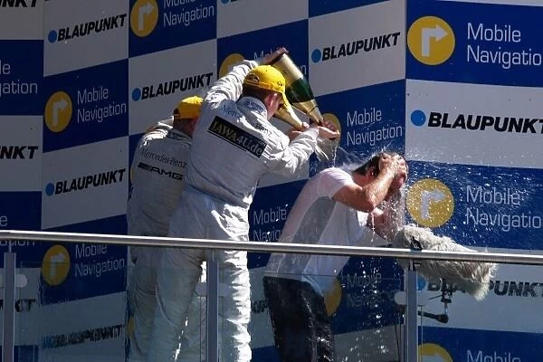 DTM. The top three drivers shower Gerhard Unger 