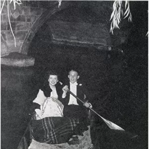 Belinda Stobart and Mr D. K. Wilson out on the river during the May Ball, held by 1st and 3rd Trinity Boat Club at Trinity College. Dancing was on the loggia and in the gardens, while the river was lit by fairy lights. Date: 1956
