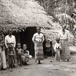 Women and children outside grass hut, Ceylon, Sri Lanka