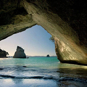 Cathedral Cove by erosion artfully sculpted rock formation seen from the inside of a natural rock arch at Cathedral Cove Cathedral Cove, Coromandel Peninsula, North Island, New Zealand