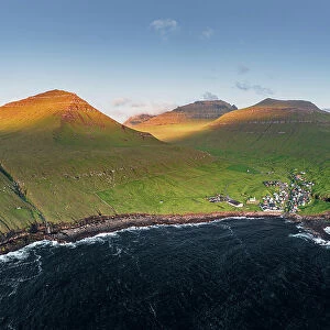 Aerial panoramic view of the village of Gjogv on cliffs washed by the ocean, Eysturoy Island, Faroe Islands, Denmark, Europe