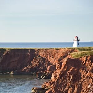 Lighthouse on a cliff overlooking a sandy beach on Havre-Aubert Island in the Iles de la Madeleine