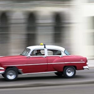 Panned shot of vintage American car on The Malecon, Havana, Cuba, West Indies, Caribbean, Central America