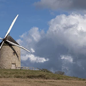 Windmill on top of a hill with a blue sky with white clouds, Normandy, France, Europe