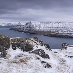 Snow covered mountain scenery above Funningsfjordur on the island of Eysturoy, Faroe Islands