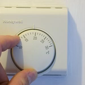 setting the central heating thermostat at a cooler temperature to save energy