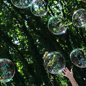 A child plays with soap bubbles at an event to support autistic children and their