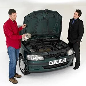 Car salesman with customer checking oil levels