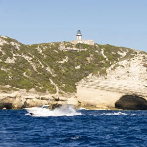 Europe, France, Corsica, Bonifacio. Boat passes Capo Pertusato lighthouse