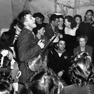 American folk singer and composer. Performing at the opening of the Washington D. C. labor canteen, sponsored by the United Federal Labor Canteen and the Congress of Industrial Organizations (CIO). Eleanor Roosevelt is in the audience. Photograph by Joseph Horne, 1944