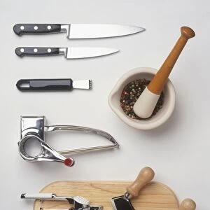 Cooking utensils, including rotary grater, knives, mezzaluna, pestle and mortar, chopping board, herb grater, garlic crusher