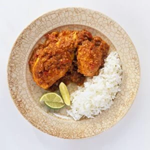 Kyet Thar Hin chicken curry served on plate with rice and slices of lime