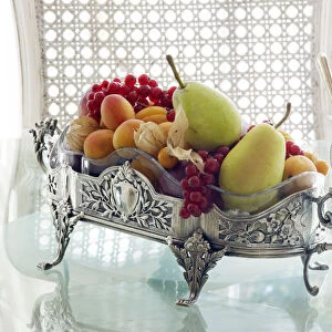 Antique silver fruit bowl with fruit in a sophisticated atmosphere on a breakfast table