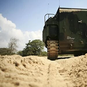 Low angle rear view of an amphibious assault vehicle driving along the beach