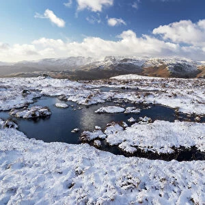 Upland peat bog on Fairfield fell covered in snow in winter, looking towards Langdale, Lake District, Cumbria, UK. January, 2022