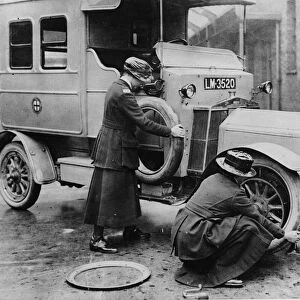 Siddeley Deasy ambulance 1911, women changing wheel. Creator: Unknown