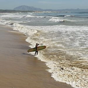 Tarifa, Costa De La Luz, Cadiz, Andalucia, Spain; A Surfer On Hurricane Hotel Beach