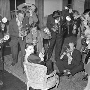 Actress Judy Garland at a press conference surronded by photographers taking