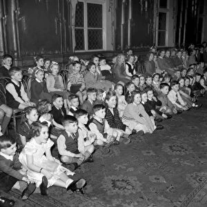 Childrens Christmas Party. Line of children sitting down watching December 1952