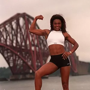Gladiator Rocket (Pauline Richards) showing her muscles with the Forth railway bridge in