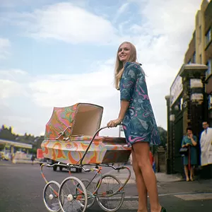 Psychedelic paisley pram with blonde woman wearing psychadelic mini dress Produced