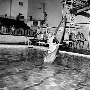 Young boy takes a canoe of a 10 feet high diving board at Bournemouth swimming pool