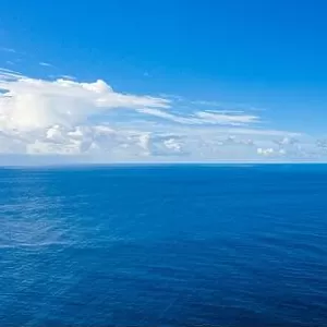 Seascape with sea horizon and almost clear deep blue sky background. Perfect sky and water, endless ocean view, blue color. Soft waves, surf concept